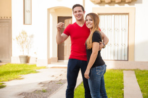 42177045 - happy young couple showing the keys to their new home and smiling