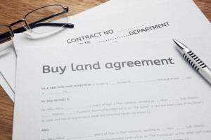 en,eyeglasses and land contract form on wood background.Bussines